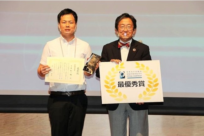 最優秀賞を受賞した牛尾聡一郎助教（左）と那須保友理事・副学長