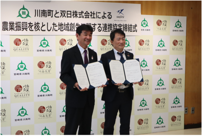 【調印式：左から川南町日高 昭彦町長、湯浅 裕司 双日執行役員 生活産業・アグリビジネス本部長】