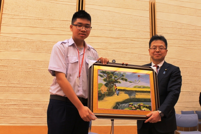 2013年度の活動（世耕官房副長官へ記念品を贈呈するベトナムの高校生）