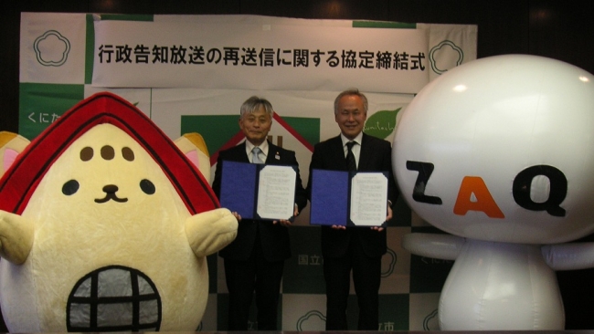 協定書を手にする東京都国立市の永見理夫市長（左） 株式会社ジェイコム多摩の谷津社長（右）
