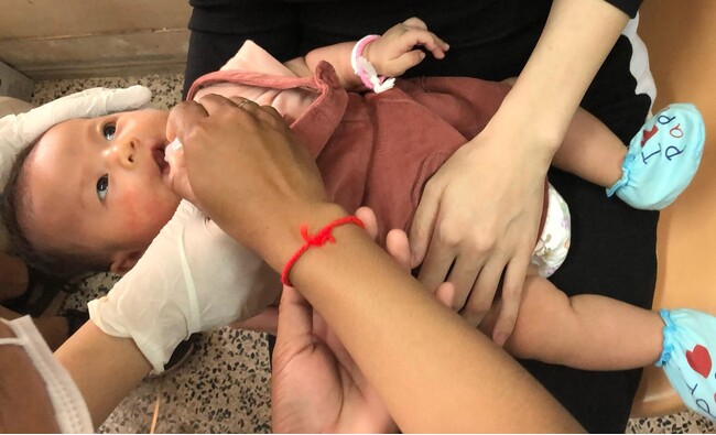 2024年3月に視察したラオスの病院でJCVの支援したポリオワクチンを接種する赤ちゃん