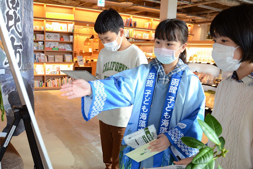 ▲来場者に「函館は昆布生産量日本一の町」と説明する子ども海藻大使