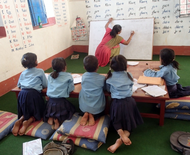 支給された机とカーペットのある教室で勉強する子どもたち（大地震の前）