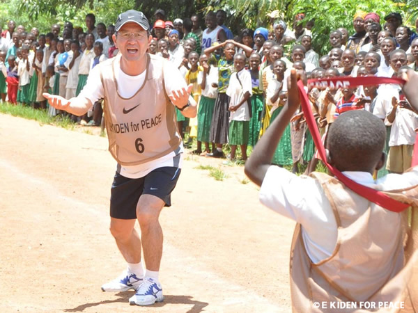 2010年2月の第2回「EKIDEN FOR PEACE」 で 難民の少年からタスキを受け取る瀬古アンバサダー（タンザニア）