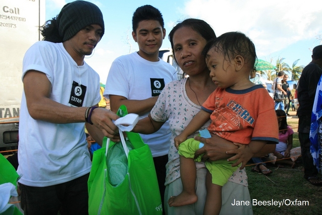 オックスファムによる支援物資セットの配布の様子。セット内容は水浄化剤(水の投入することで殺菌し、飲める状態にするもの)、 蚊帳（かや)、毛布、マットレス、歯ブラシ等。