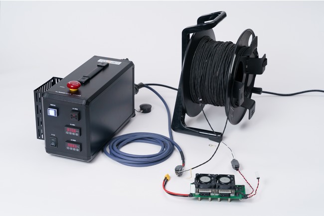 フカデンが開発したドローン向け有線給電ユニット「電源制御BOX II メイン電源ユニット」（写真左奥）とVicorのDCMシリーズを2つ採用したドローン搭載電源部分（写真右前）