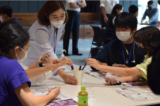 実験教室で、銅の性質について学ぶ参加者の様子