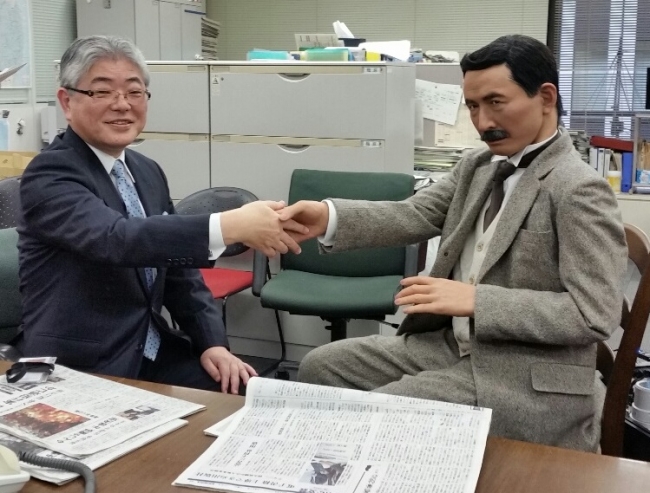 漱石アンドロイドと握手する朝日新聞社の渡辺雅隆社長