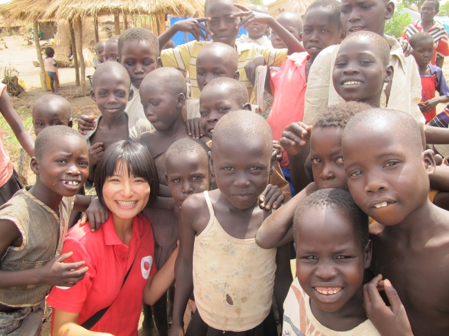 AARが教育支援を行っているウガンダ・ビディビディ難民居住地の子どもたちと駐在員の河津志貴保（かわづしきほ）