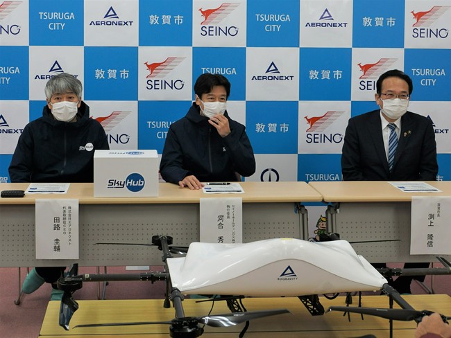 実証実験の背景や概要を説明する写真向かって 右より敦賀市長渕上隆信、セイノーHD執行役員 河合秀治、エアロネクスト代表取締役CEO田路圭輔 実証実験の背景や概要を説明する写真向かって 右より敦賀市長渕上隆信、セイノーHD執行役員 河合秀治、エアロネクスト代表取締役CEO田路圭輔