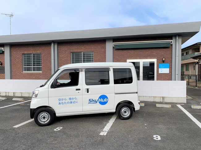 「ドローンデポ境町」外観とSkyHub(R)サービスに使用する軽バン 「ドローンデポ境町」外観とSkyHub(R)サービスに使用する軽バン