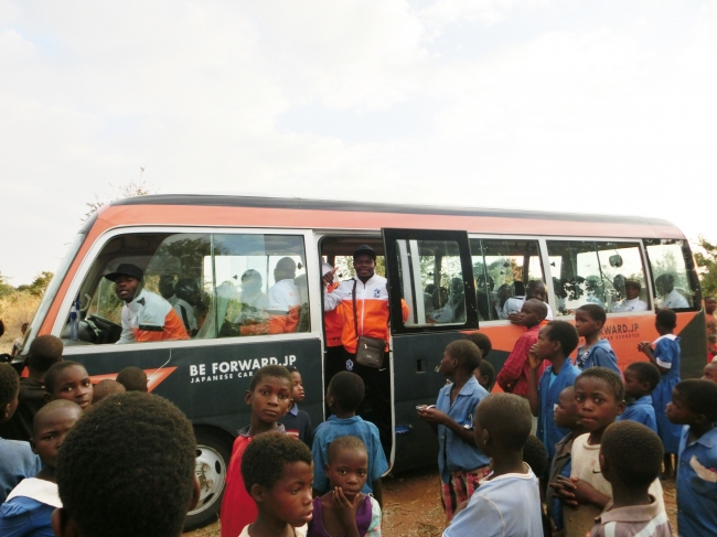 子どもたちに囲まれるチーム移動バス