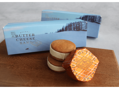 【新千歳空港限定発売】3か月で35,000個を突破した人気商品「北のごちそう バターチーズサンド」に前田真三氏作品の限定パッケージ「冬景色」登場！北海道バターケーキも販売開始