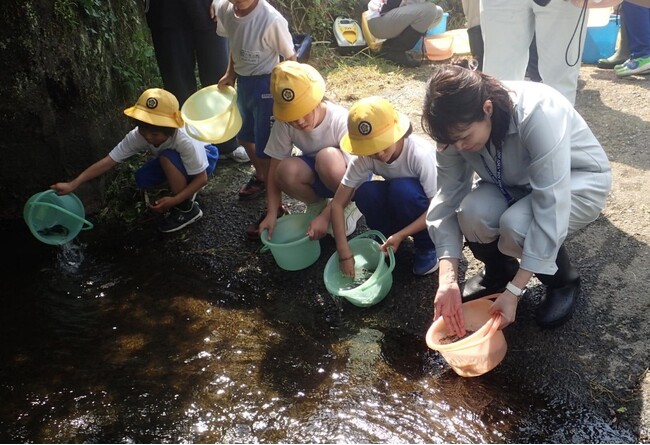 NOKグループ北茨城地区3社、大北川のアユ稚魚放流体験活動に参画　地元小学生とアユ稚魚30kgを放流し、北茨城市の環境保全を支援